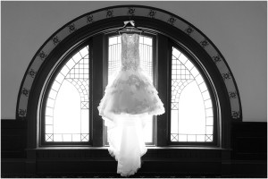 Picture of a wedding dress in a window.